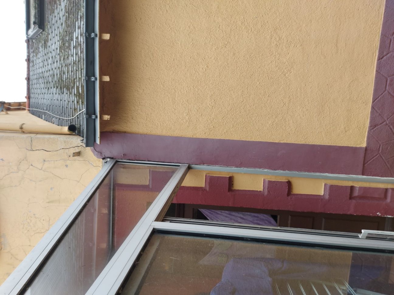 Tassement différentiel entre une maison et son extension, provoquant une fissure traversante :  